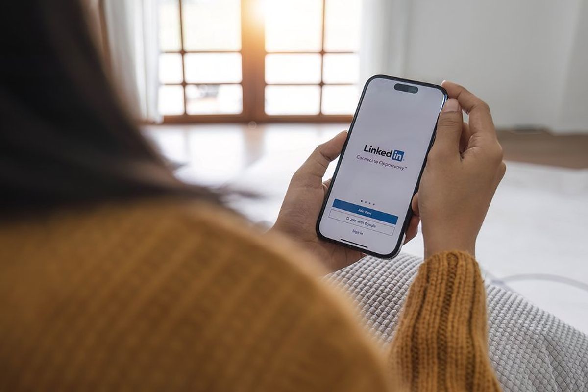 Woman opens the LinkedIn app on her phone