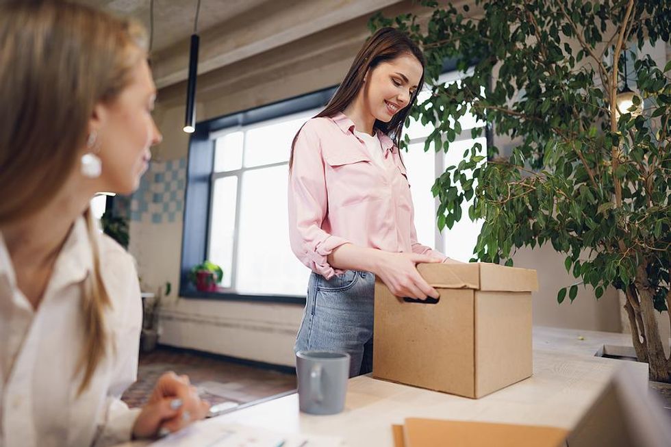 Woman packs up her desk before leaving her job