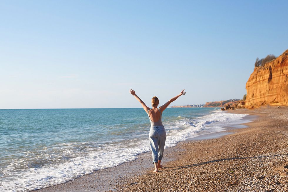 Woman practices grounding (earthing) at the beach