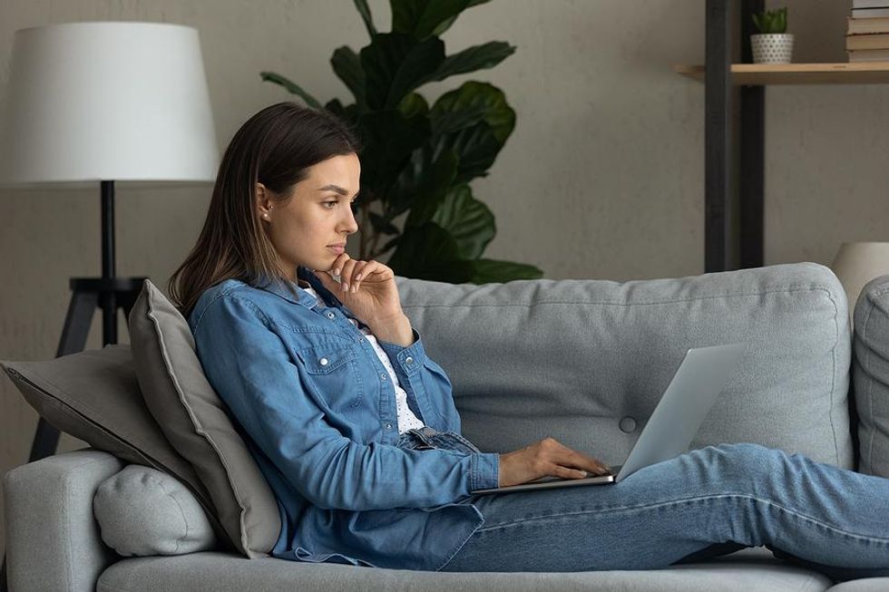 Woman reads her resume on her laptop