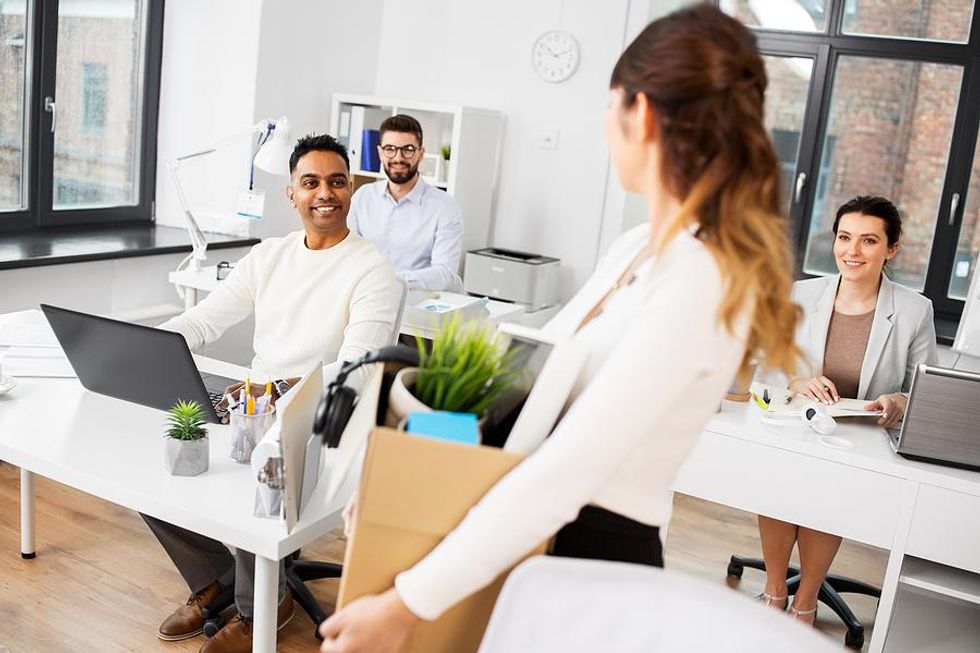 Woman says goodbye to her coworkers as she leaves her job