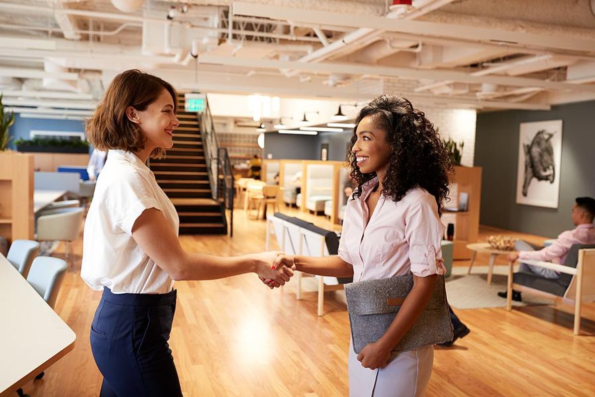 Woman shakes hands with a colleague