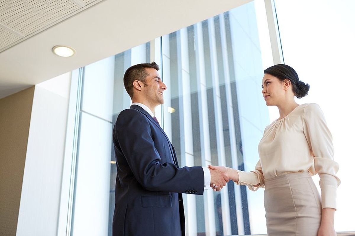 Woman shakes hands with the CEO before her job interview