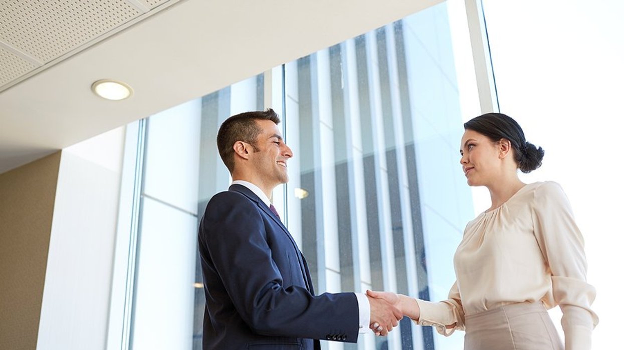 Woman shakes hands with the CEO before her job interview