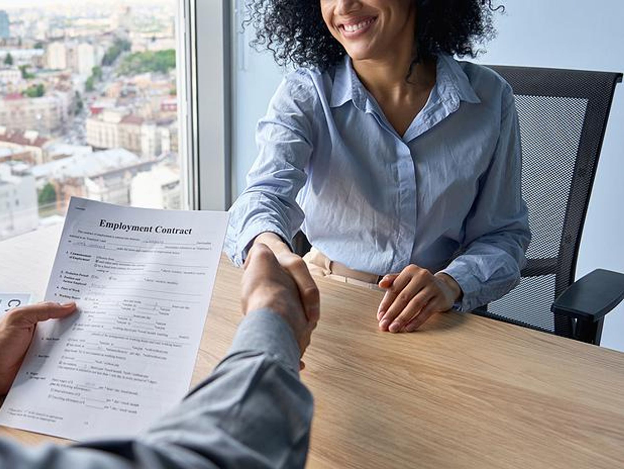 Woman shakes hands with the hiring manager after a job interview
