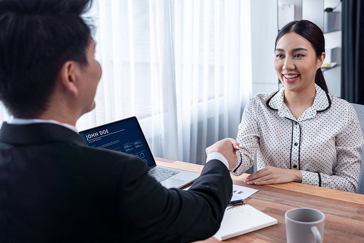 Woman shakes hands with the hiring manager after impressing him during her job interview