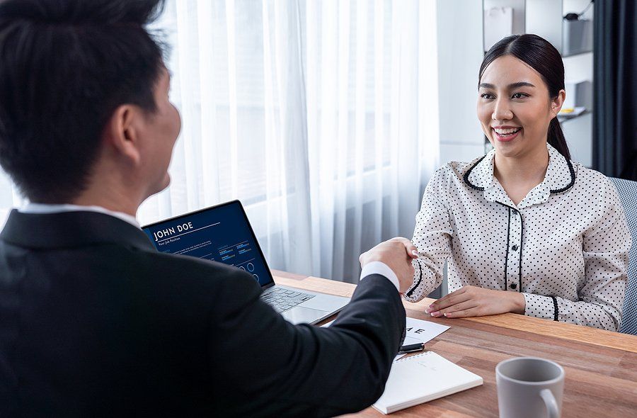 Woman shakes hands with the hiring manager after impressing him during her job interview