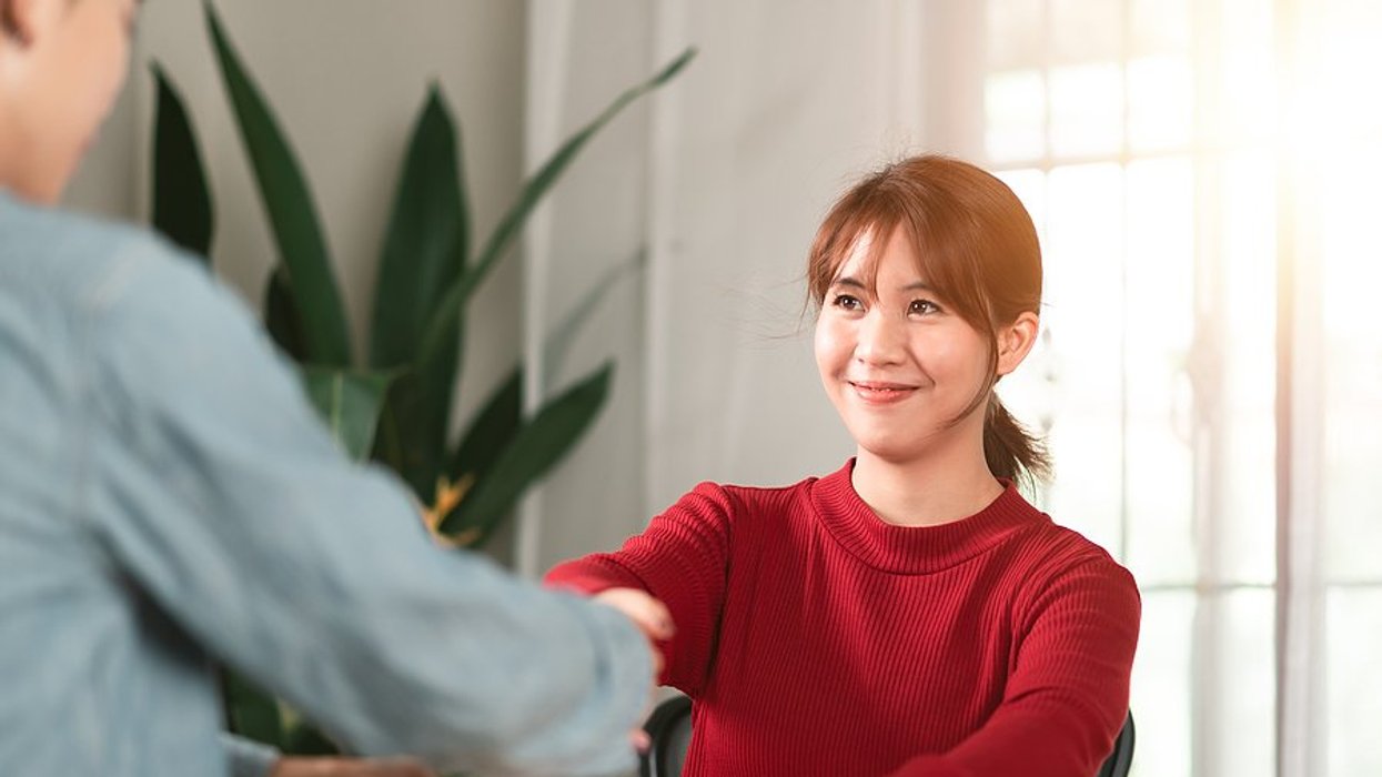 Woman shakes hands with the hiring manager before a job interview and hopes to make a great first impression
