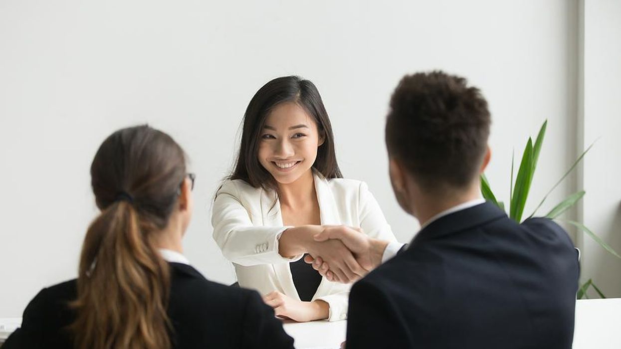 Woman shakes hands with the hiring manager before a job interview