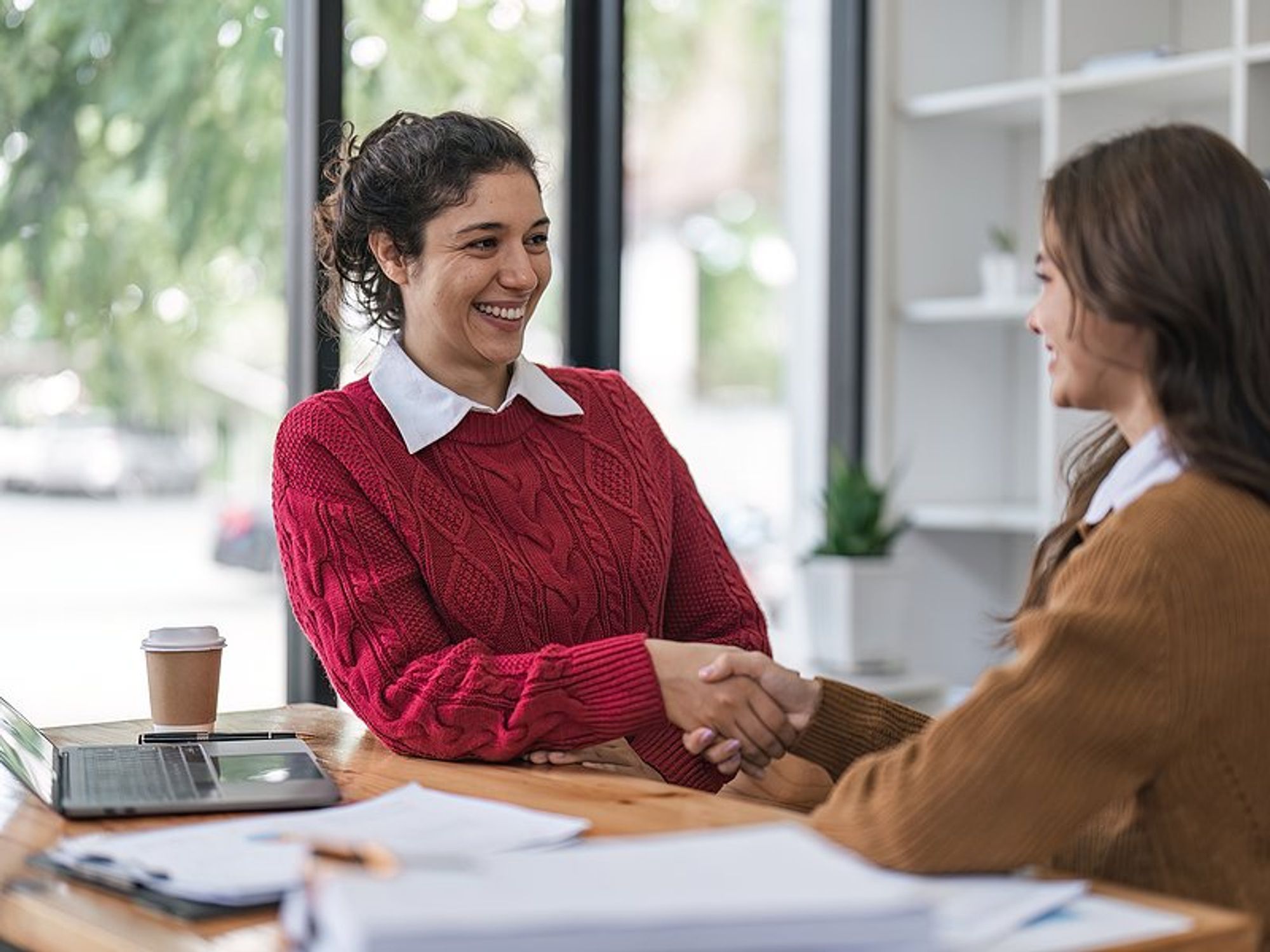 Woman shakes hands with the hiring manager before a job interview