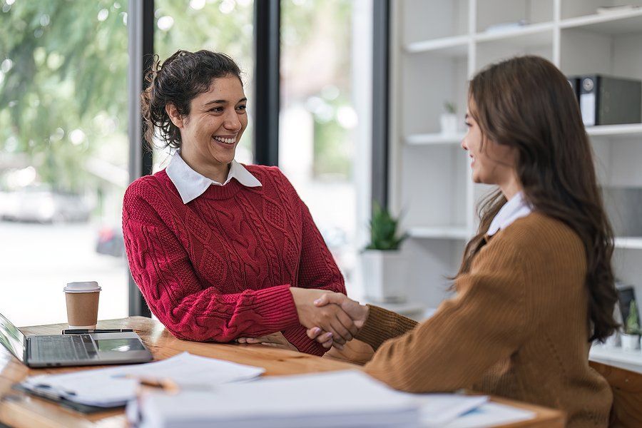 Woman shakes hands with the hiring manager before a job interview