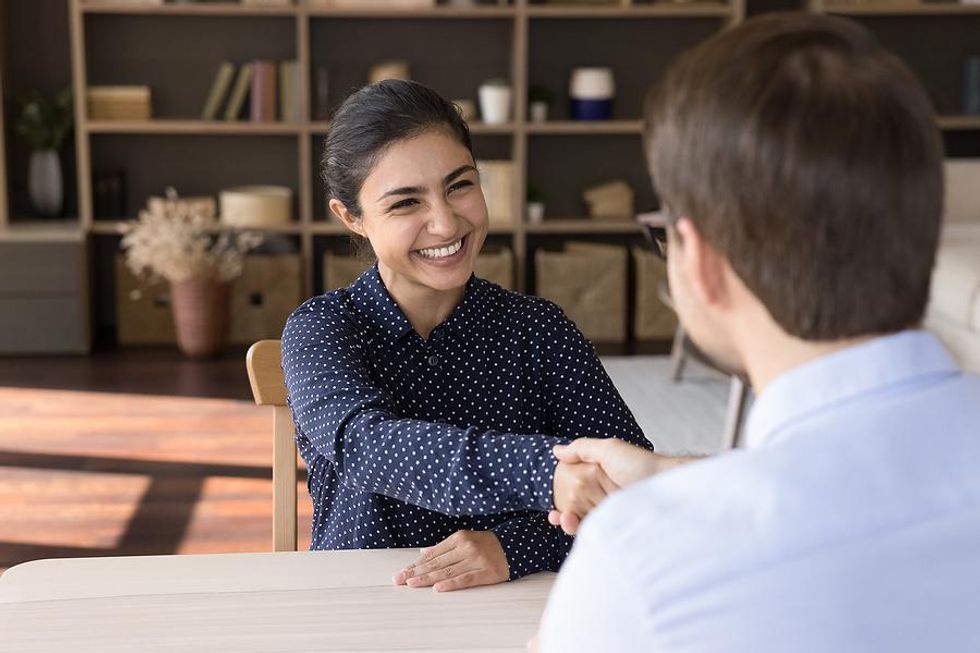 Woman shakes hands with the hiring manager before her job interview