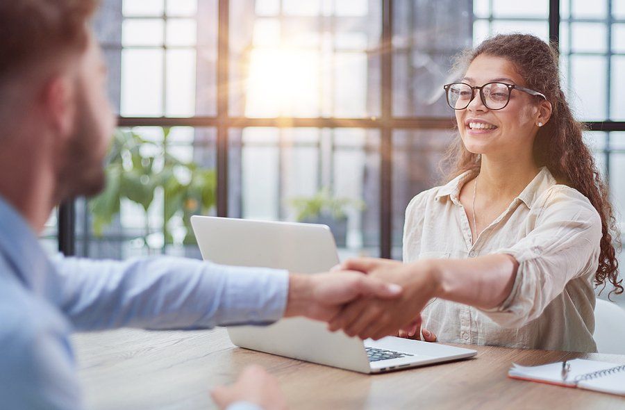 Woman shakes hands with the job applicant after his interview
