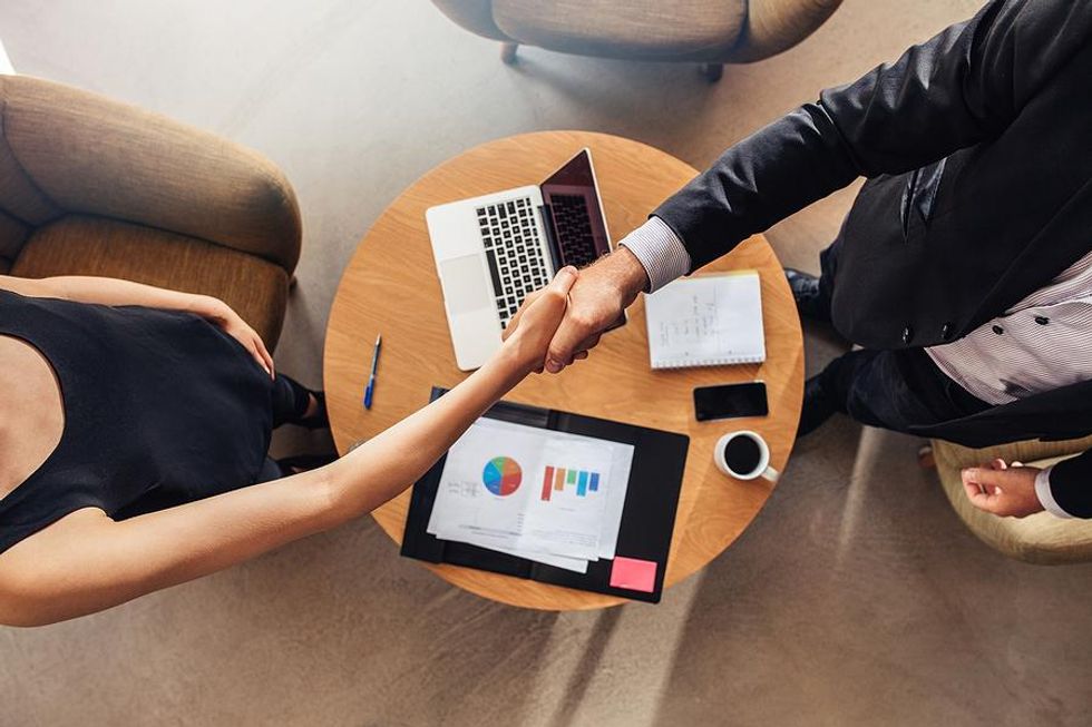 Woman shakes hands with the recruiter / hiring manager before a job interview