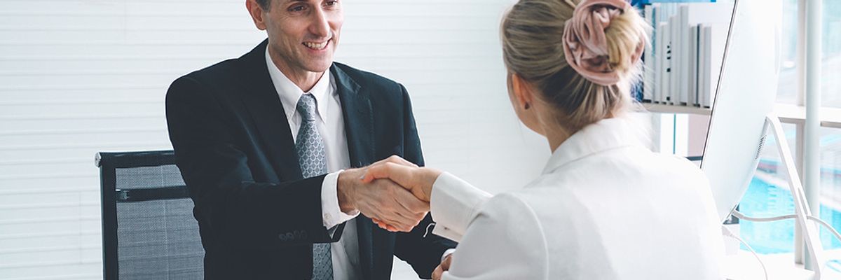 Woman shakes the hand of a hiring manager during a job interview