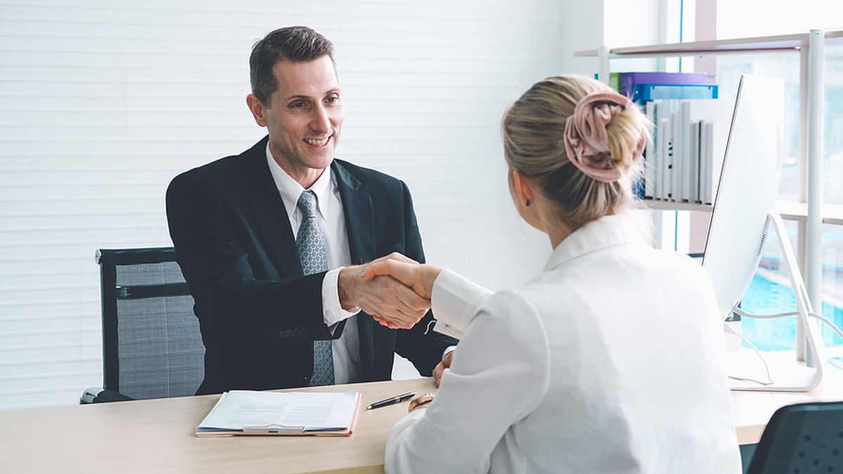 Woman shakes the hand of a hiring manager during a job interview