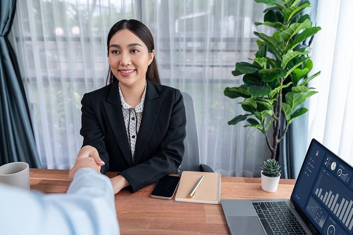 Woman shaking hands with the hiring manager stays calm and confident in a job interview