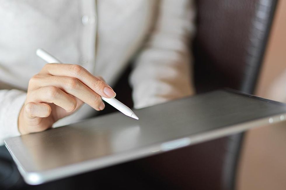 Woman takes notes on tablet at work