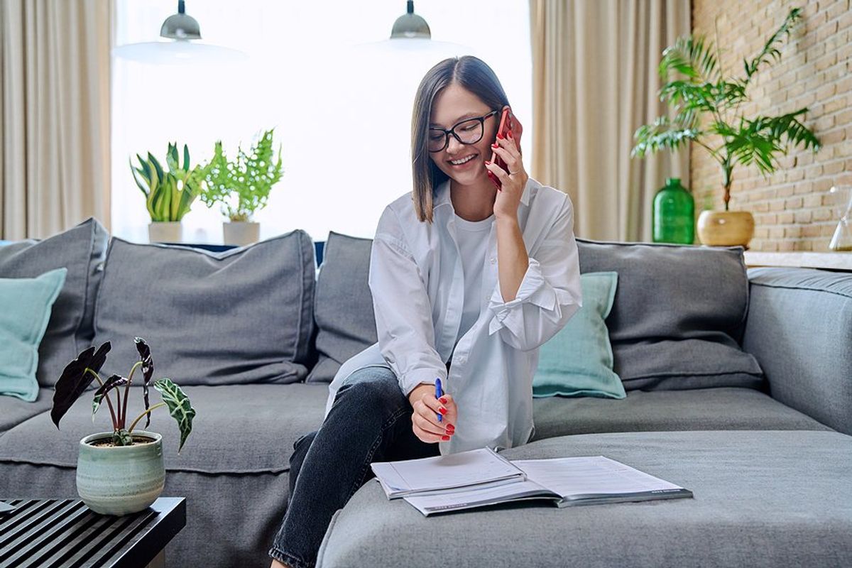 Woman talking on phone is prepared for her phone interview
