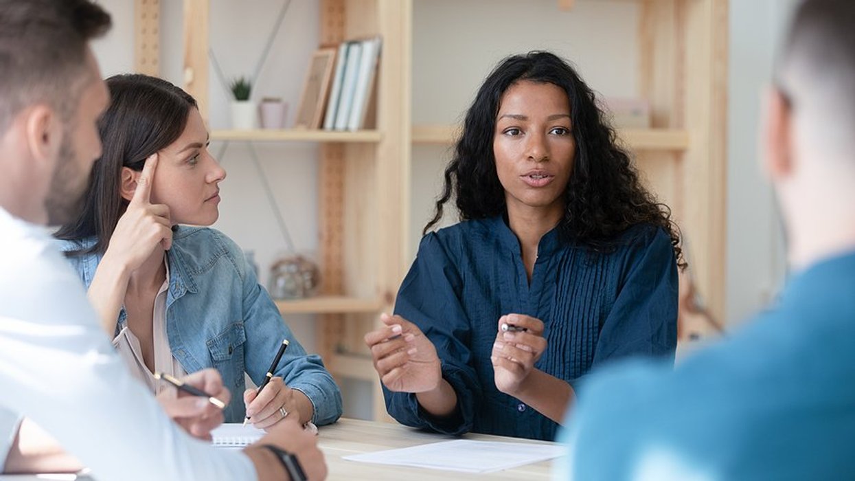 Woman talks to coworkers during a work meeting