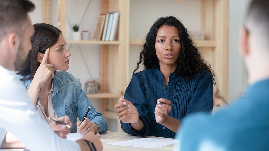 Woman talks to coworkers during a work meeting