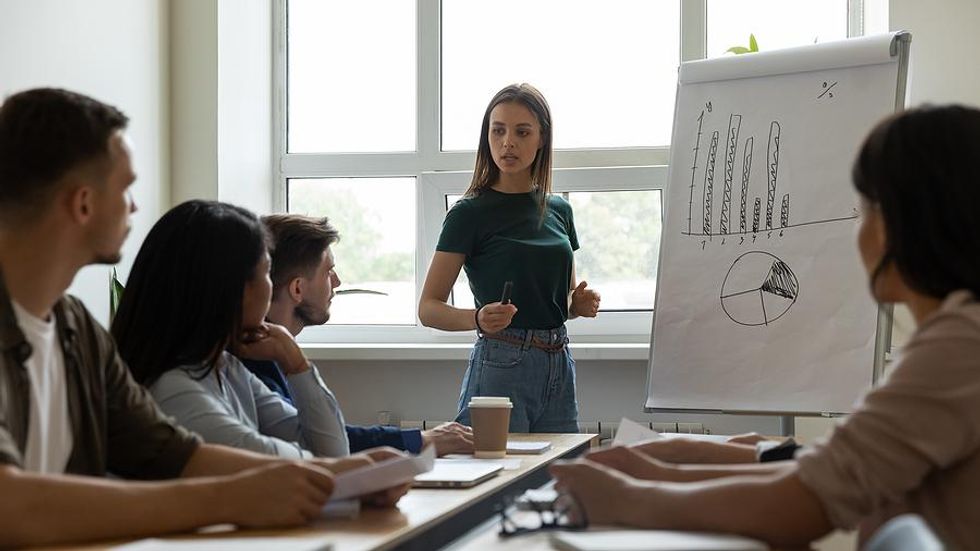 Woman talks to employees about layoffs during a work meeting