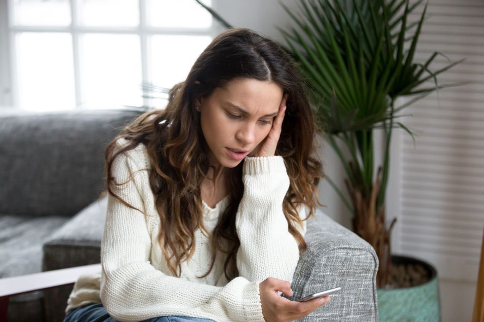 Woman waiting for a job offer looks at her phone