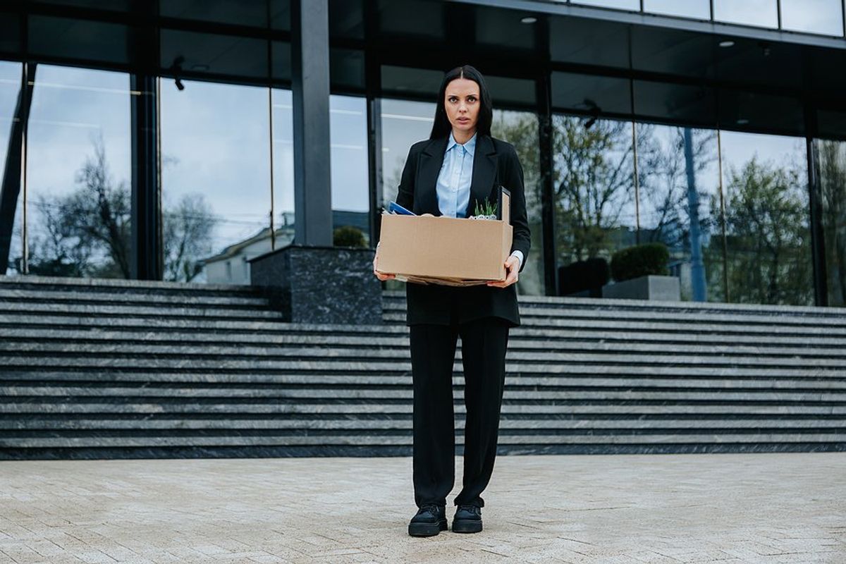 Woman who recently got fired/laid off holds a box of her things