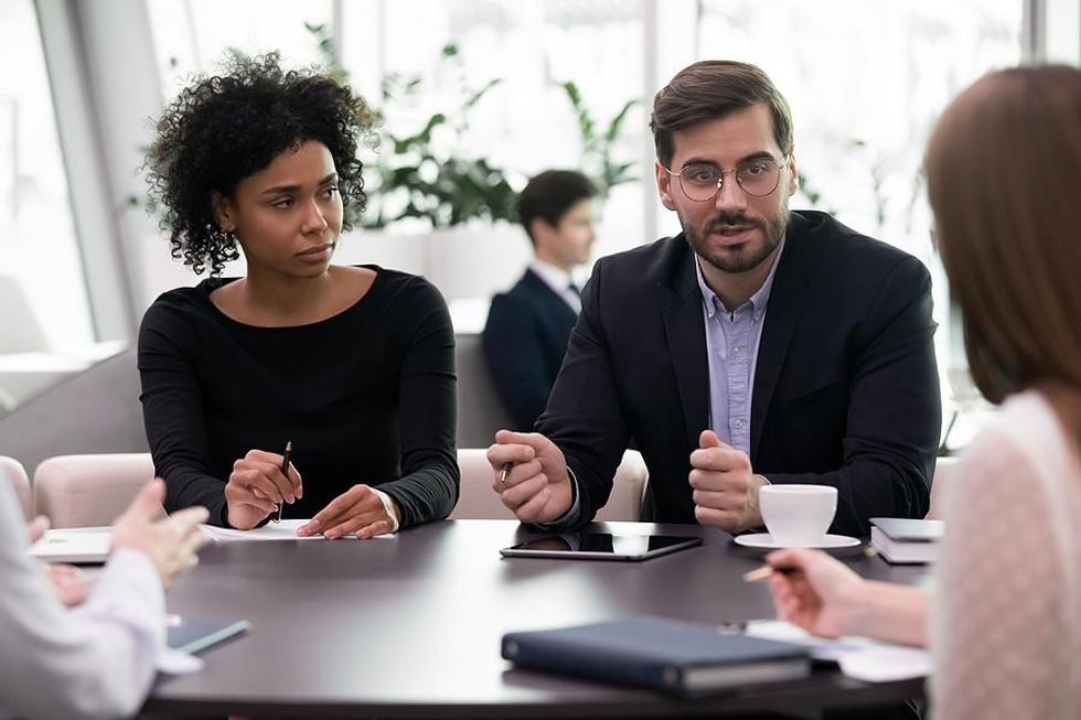 Women listens to her bad boss during a meeting
