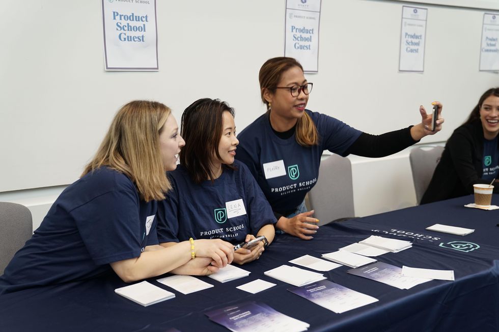 Women sit at a tradeshow booth