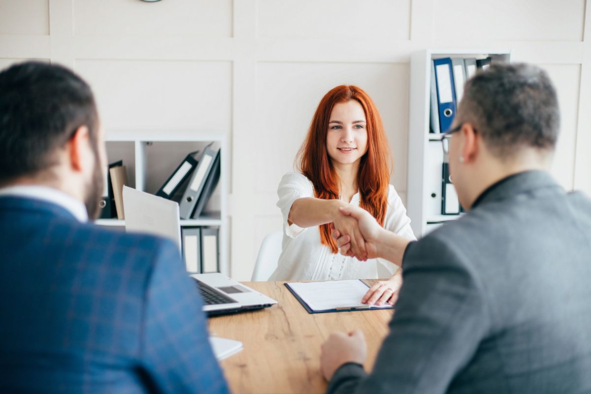 Women who is trying to break her job-hopping habit shakes hands with the hiring manager during a job interview  