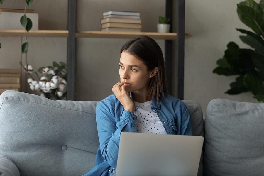 Worried woman on laptop thinks about quitting her job