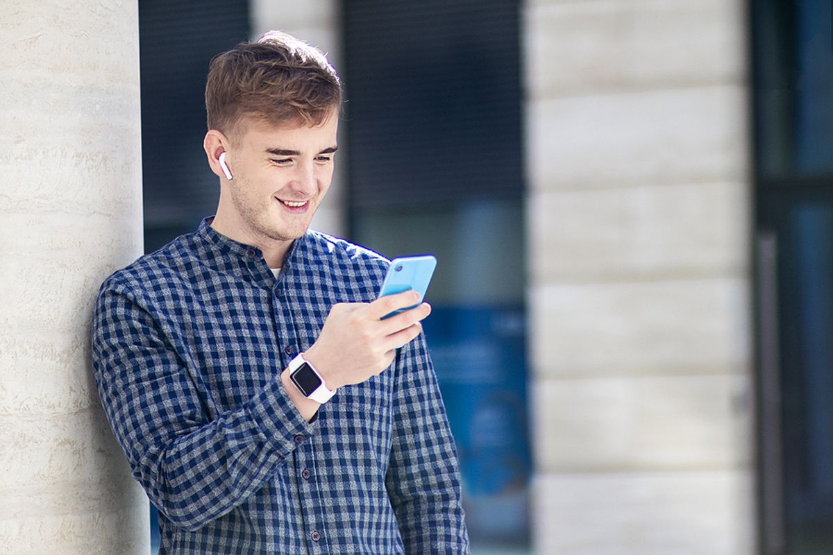 Young man listens to podcast episodes while walking around the city