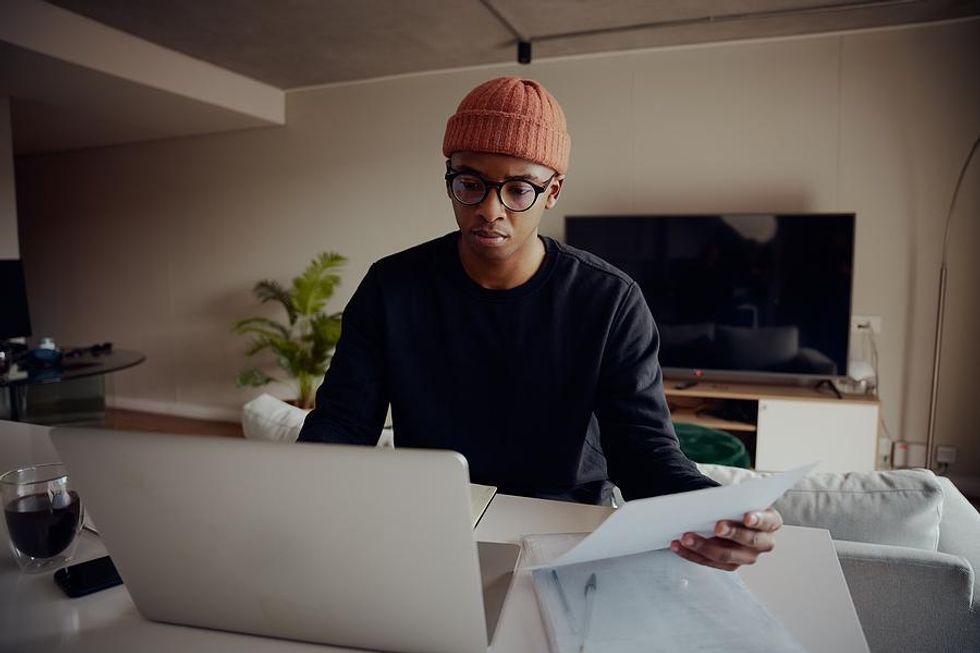 Young man on laptop updates his resume