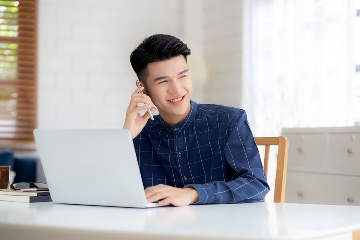 Young man smiles while on the phone with a job lead
