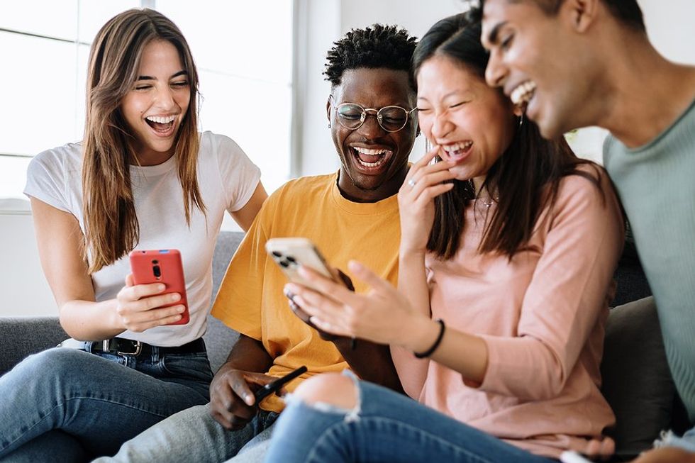 Young people on their phones laughing at a video of one of their favorite brands