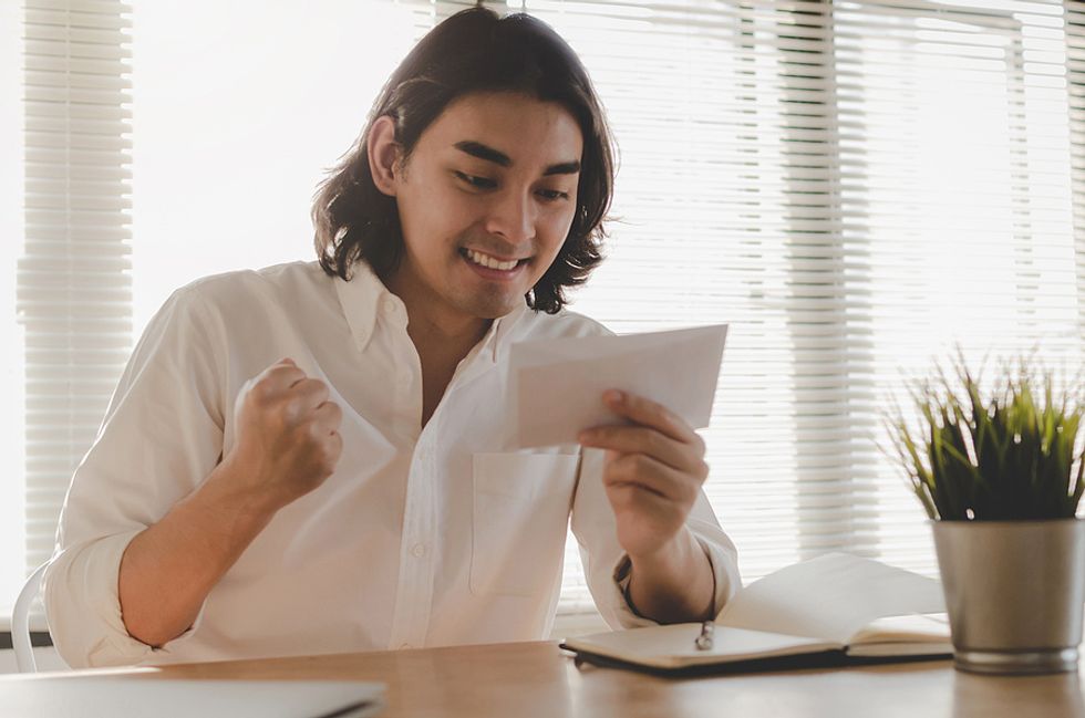 Young professional is happy to receive his first paycheck