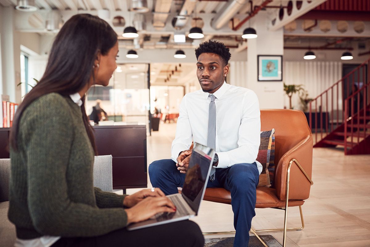 Young professional man being interviewed in a modern office.