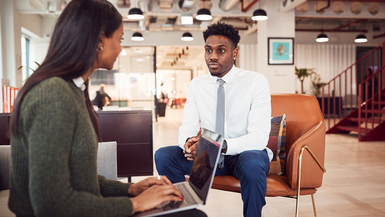 Young professional man being interviewed in a modern office.