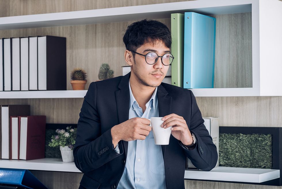 Young professional man drinking coffee and taking a break from work