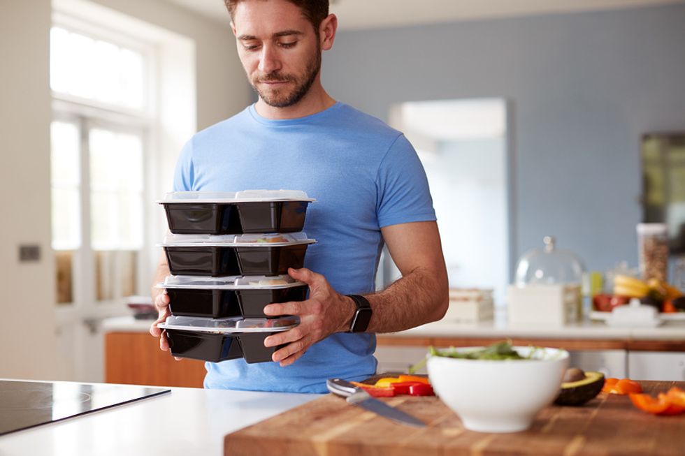 Young professional man preparing healthy meals after being laid off from his job
