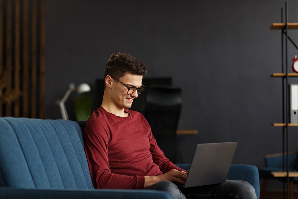 Young professional on laptop shares content with his network on LinkedIn