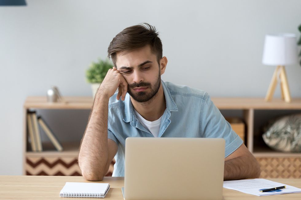 Young professional on laptop with wrong attitude at work is at risk of getting fired