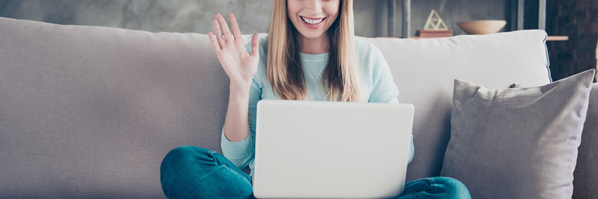 Young professional raises her hand during a remote workplace game.