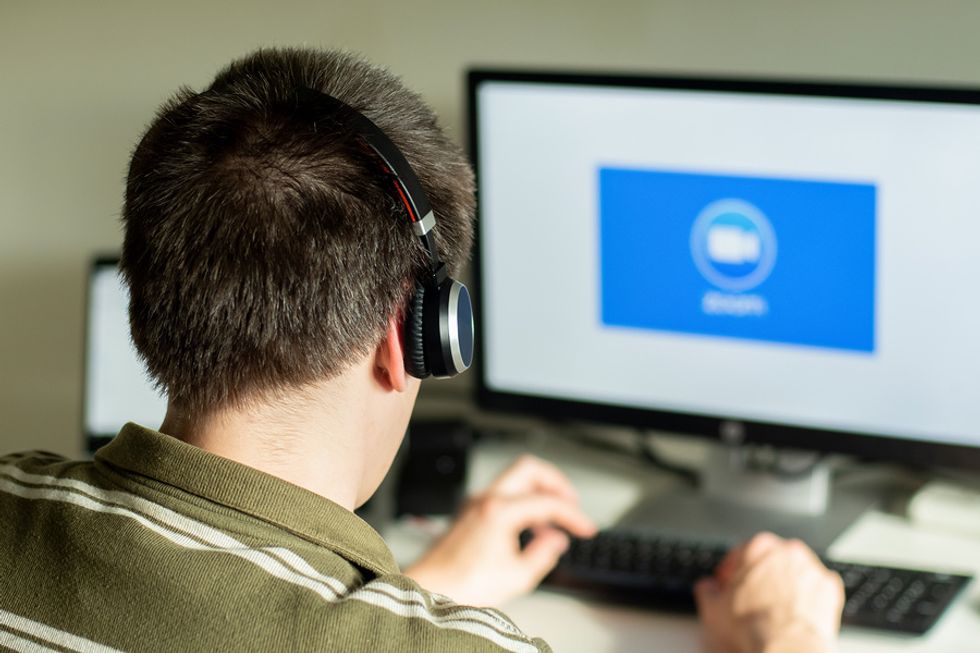 Young professional signs on to take part in a video conference.