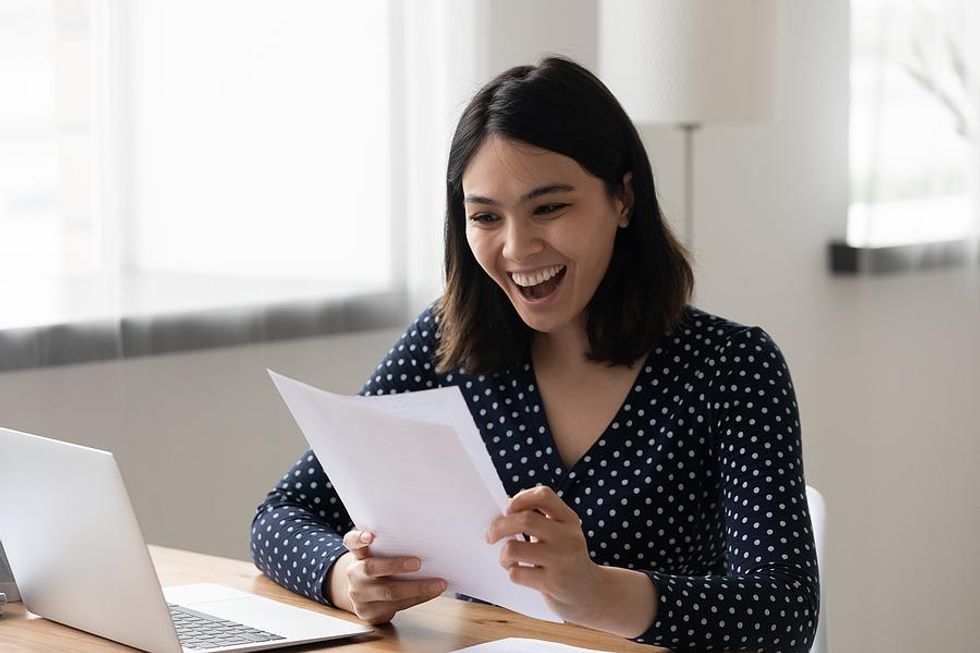 Young professional smiles as she celebrates a career accomplishment.
