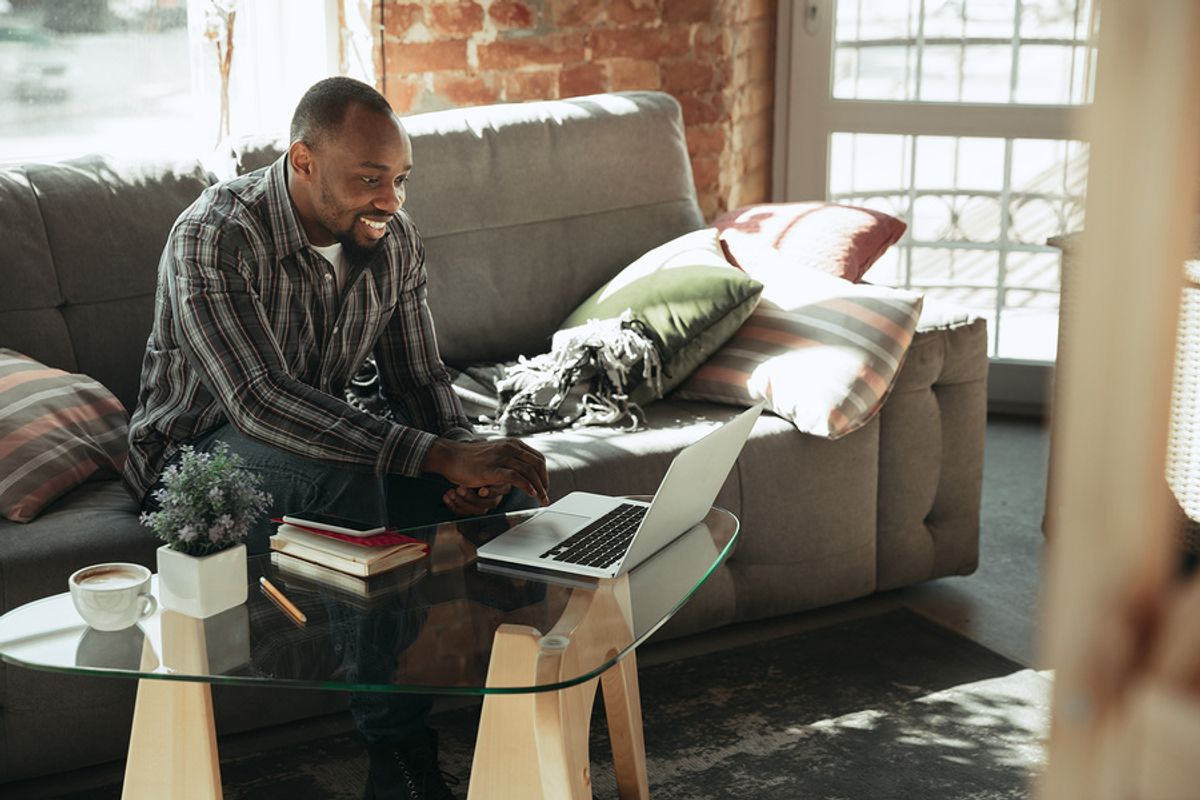 Young professional smiles during a remote work video meeting.