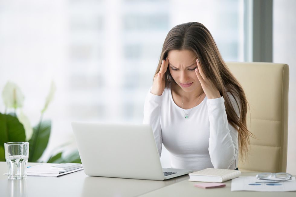 Young professional woman looking stressed at her job, debating whether she should look for a new job