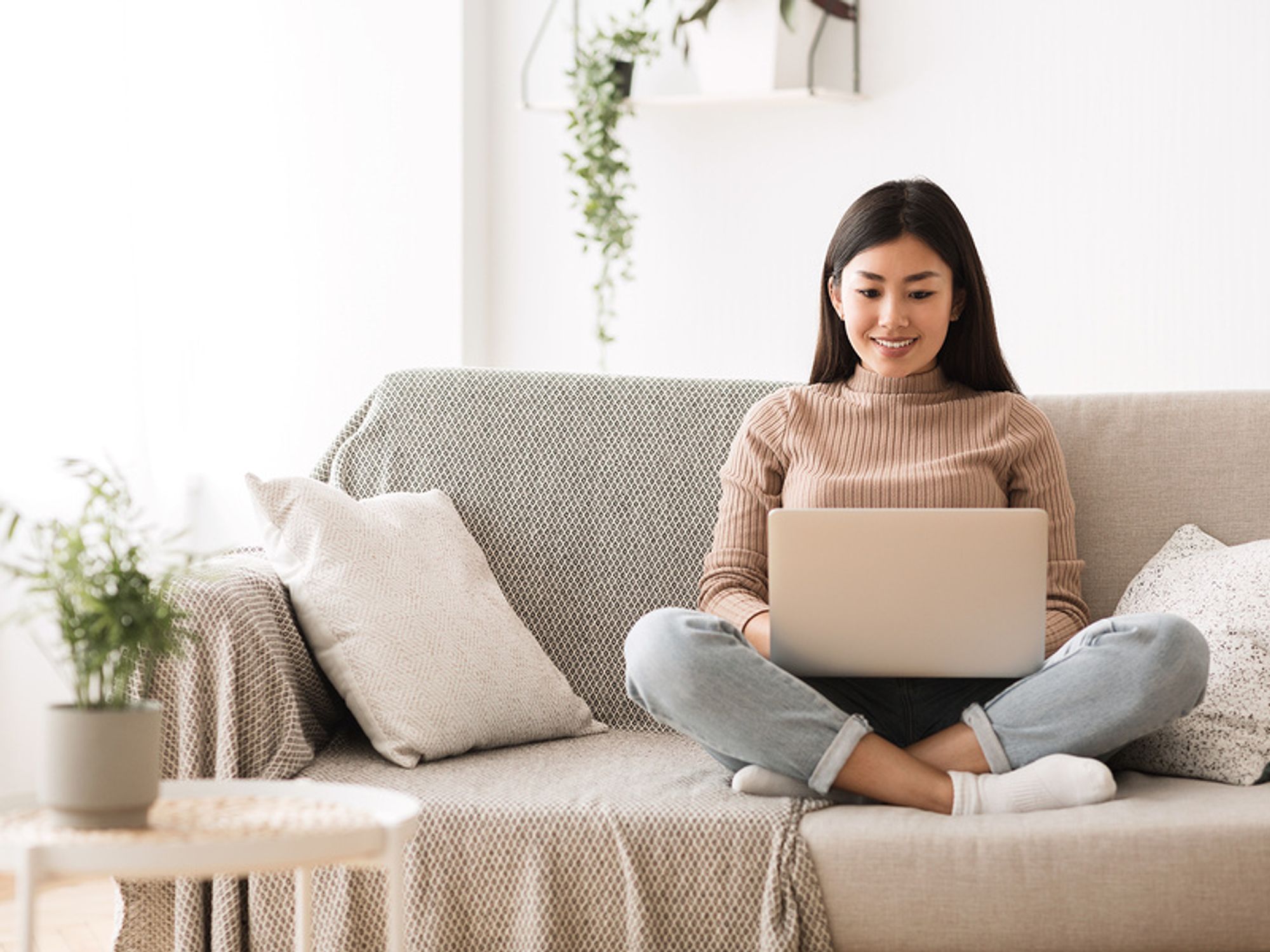 Young professional woman on laptop searches job postings online