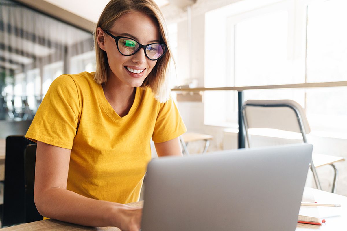 Young professional woman on laptop takes some spare time to work on her career plan